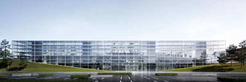 Glass-fronted office building with reflective façade in a parking lot, flanked by green slopes and trees.