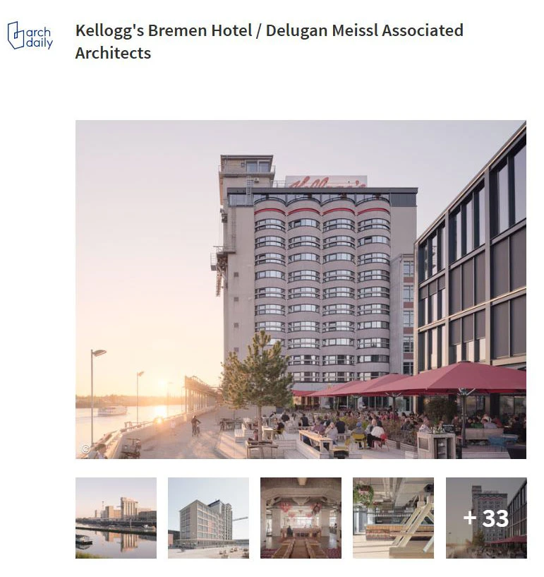 Hotel building with curved glass facade on a riverfront promenade; outdoor seating under red umbrellas at sunset.