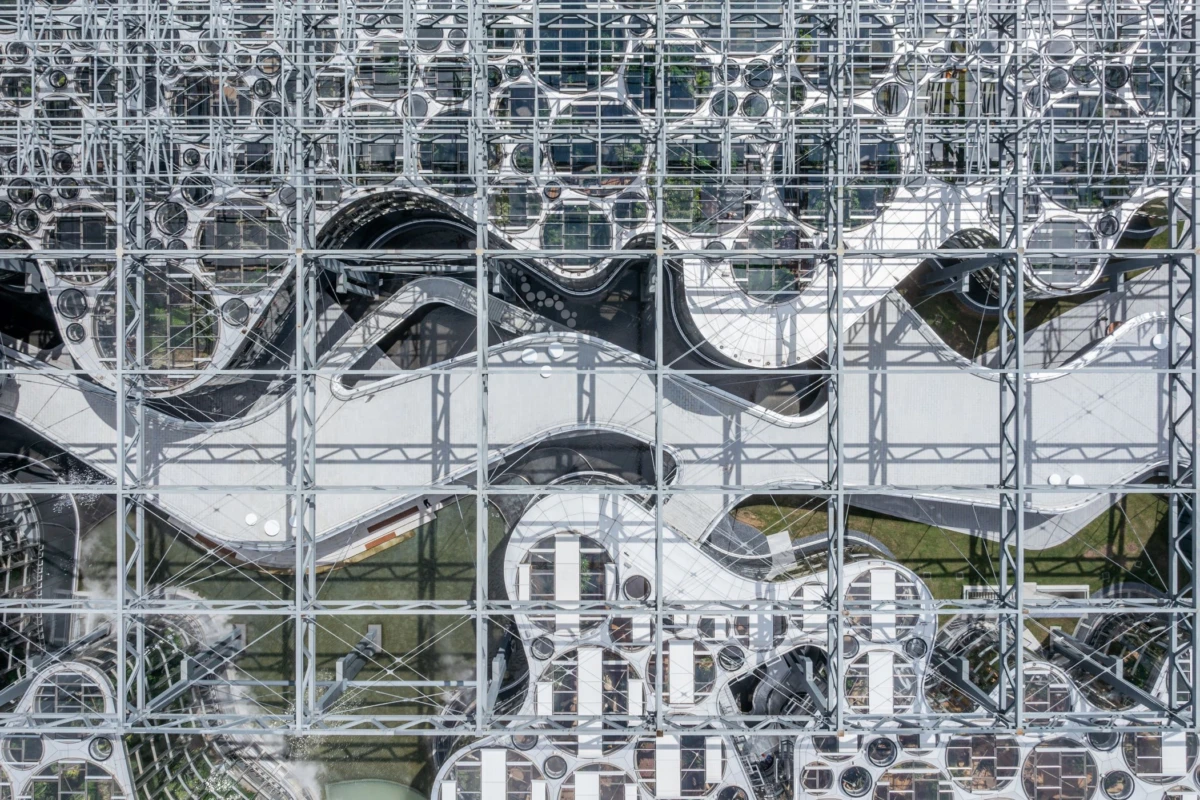 Exterior view of a modern metal lattice facade with curved reflective panels creating abstract patterns.