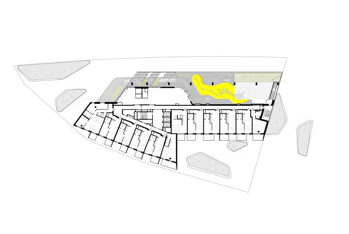Architectural floor plan of a triangular building with a long central corridor and repeated rooms; surrounding site landscaping and a yellow curved pathway.