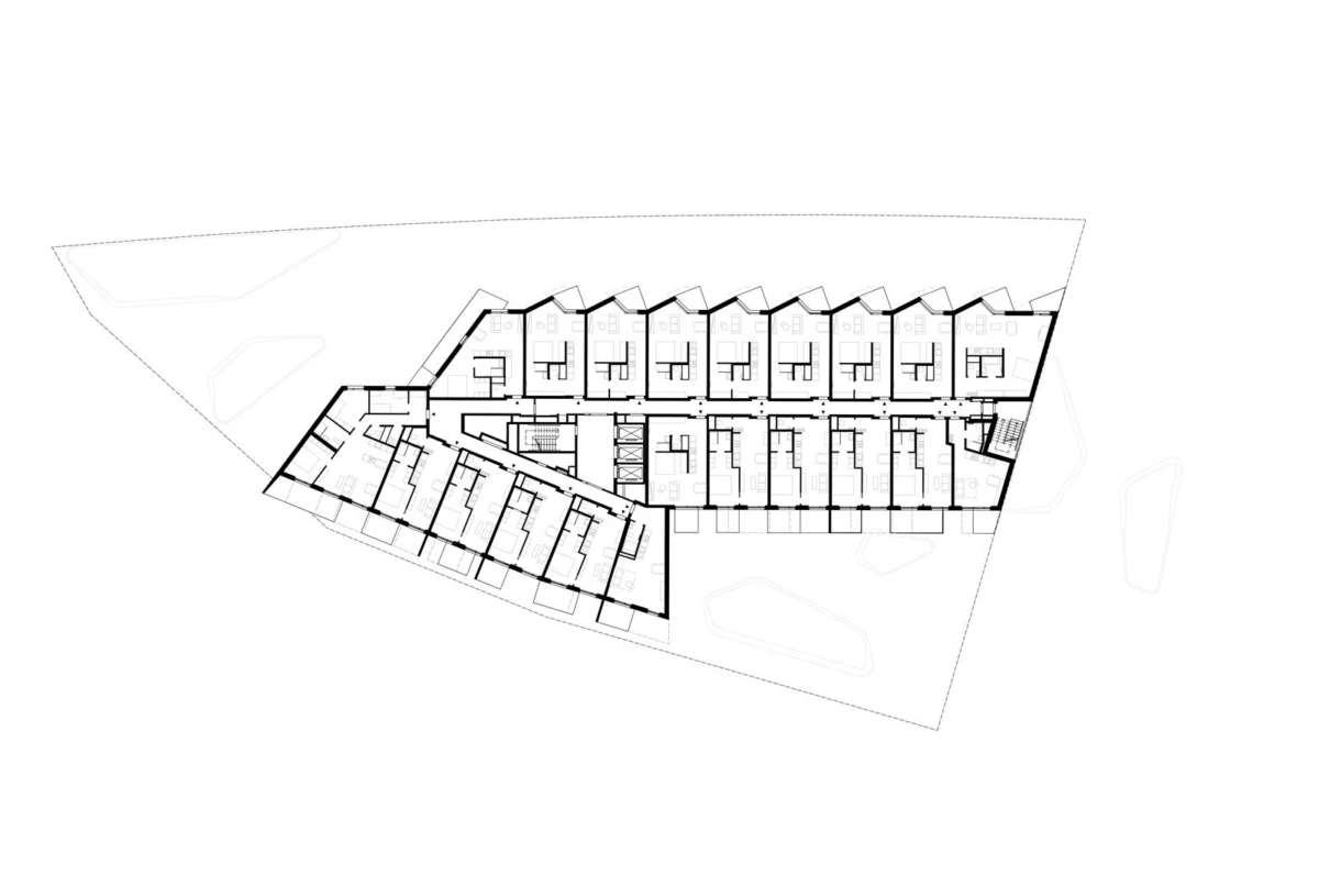Architectural floor plan of a multi-unit building with a central corridor and numerous individual rooms along both sides.