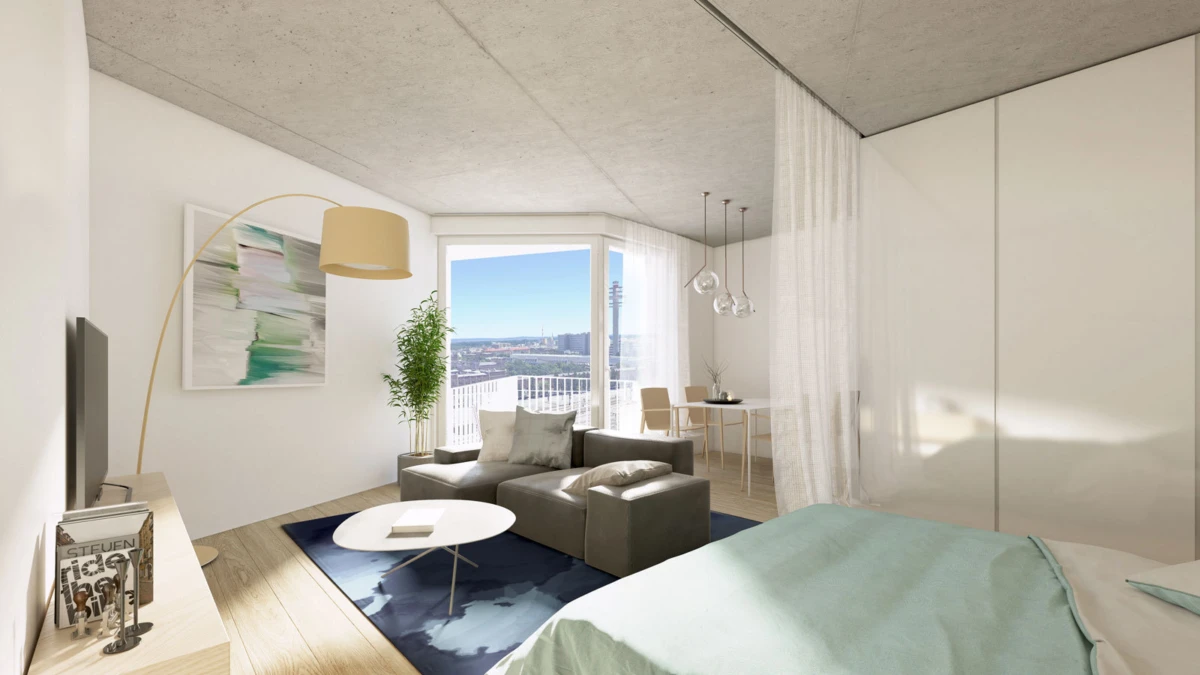 Modern open-plan studio with bed in foreground, sofa and coffee table, dining area, and large window overlooking the city.
