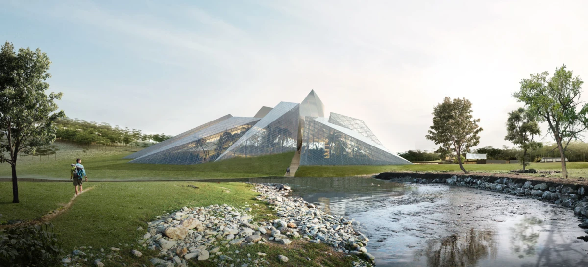 Glass pyramid pavilion in a park beside a pond; a person with backpack walks along a path toward it.