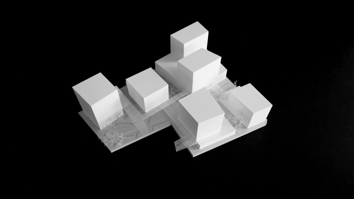 Architectural scale model of white cubic buildings arranged on a platform with a transparent grid, against a black background.