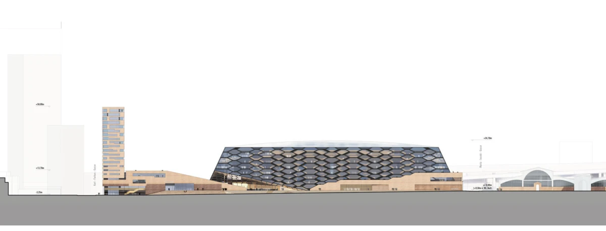 Modern cultural center with a hexagonal-patterned dark-blue roof atop a brick base, and a tall left tower in an urban streetscape.
