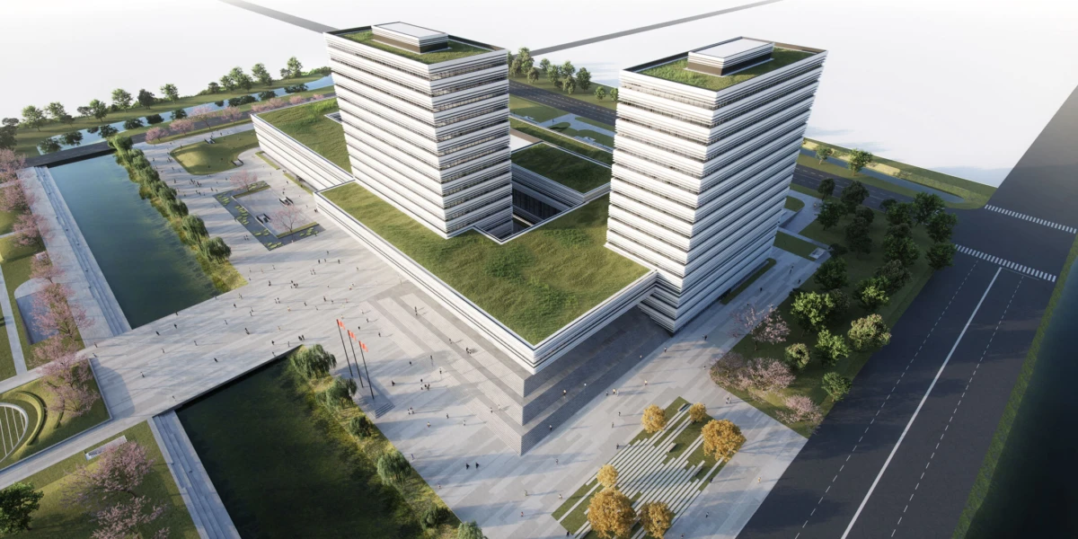 Aerial view of a modern office campus: two tall white rectangular towers with green roofs, connected by platforms, beside a canal and expansive plaza.