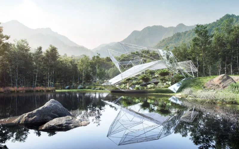 Geometric glass pavilion on a grassy bank beside a tranquil lake, surrounded by forest and mountains, mirrored in the water.