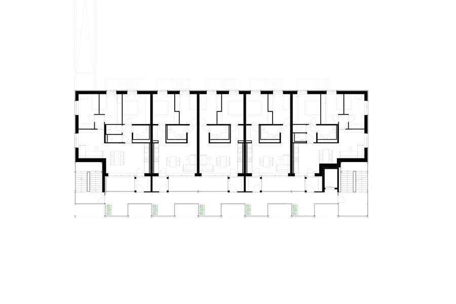 Architectural floor plan of a rectangular multi-unit residential building with a central corridor and repeating apartment units; stairs at each end.