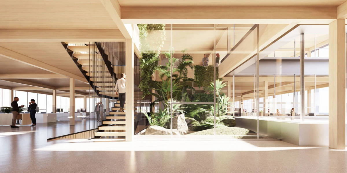 Modern office interior with glass walls and an indoor garden; curved wooden staircase beside lush plants, with people mingling.