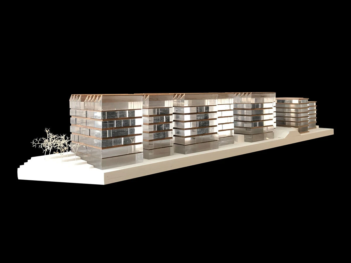 Scale model of a modern glass-clad building complex on a white base with trees, against a black background.