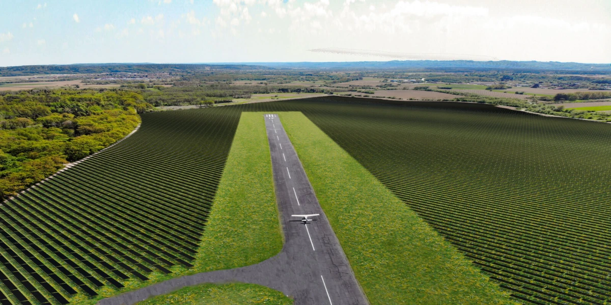 Light aircraft on a paved runway flanked by long rows of grapevines in a rural farmland landscape.
