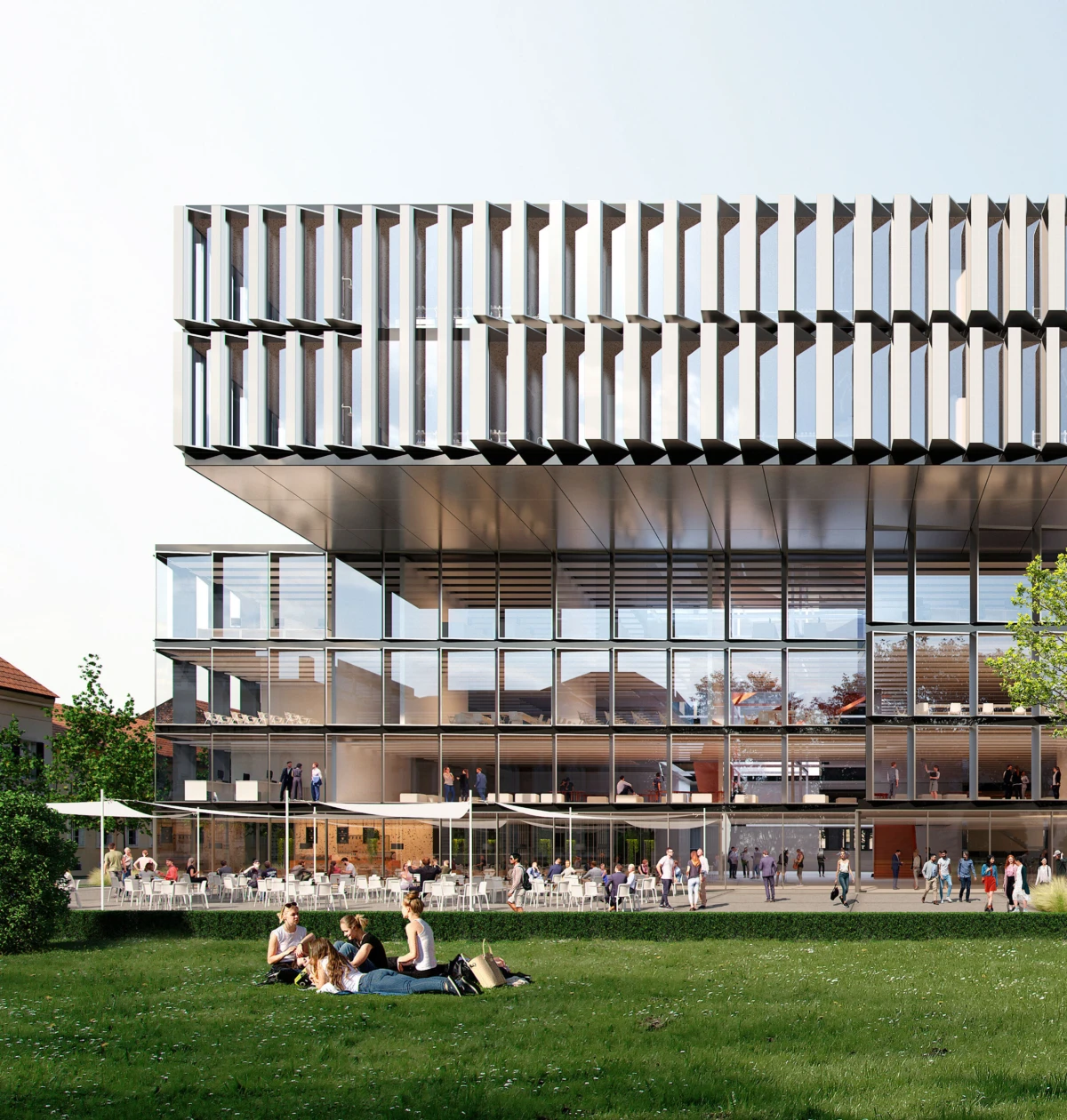 People picnicking on a grassy lawn in front of a contemporary glass office building with a striped, overhanging upper facade and outdoor seating.