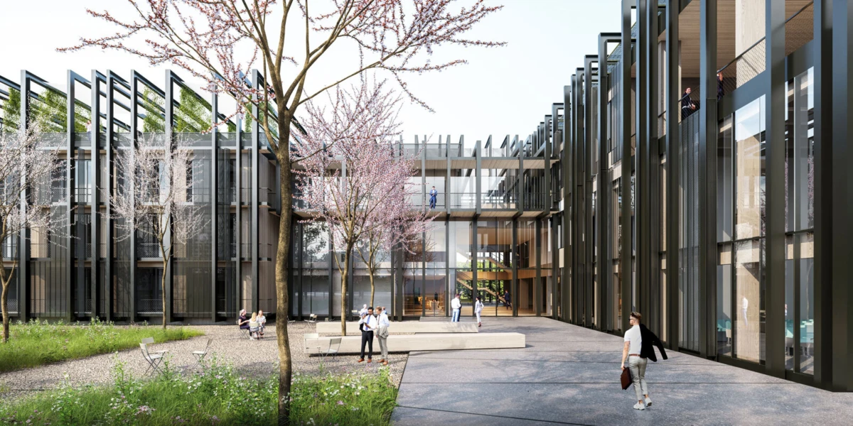Modern glass-front courtyard between tall steel-framed buildings; people stroll, chat, and sit near blossoming cherry trees.