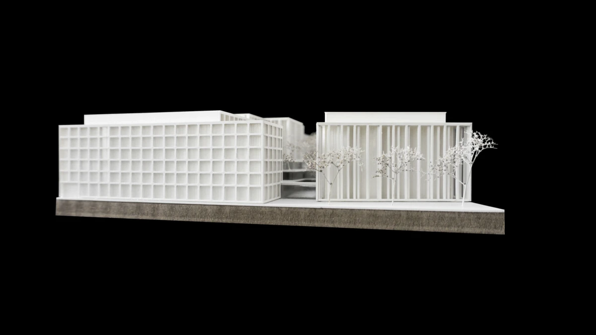 Architectural scale model of two modernist buildings with a central courtyard, white trees between them, mounted on a base against a black backdrop.