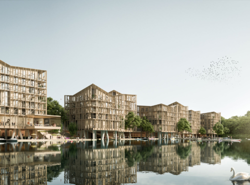 Wooden-framed residential complex by a calm lake, with reflected buildings, boats, trees, and a flock of birds in the sky.