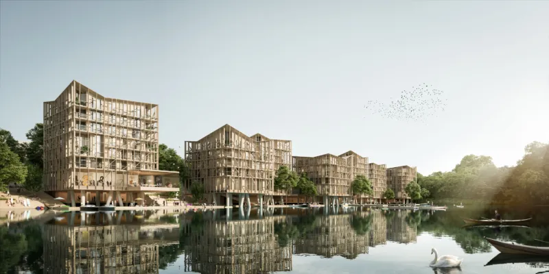 Wooden-framed residential complex by a calm lake, with reflected buildings, boats, trees, and a flock of birds in the sky.
