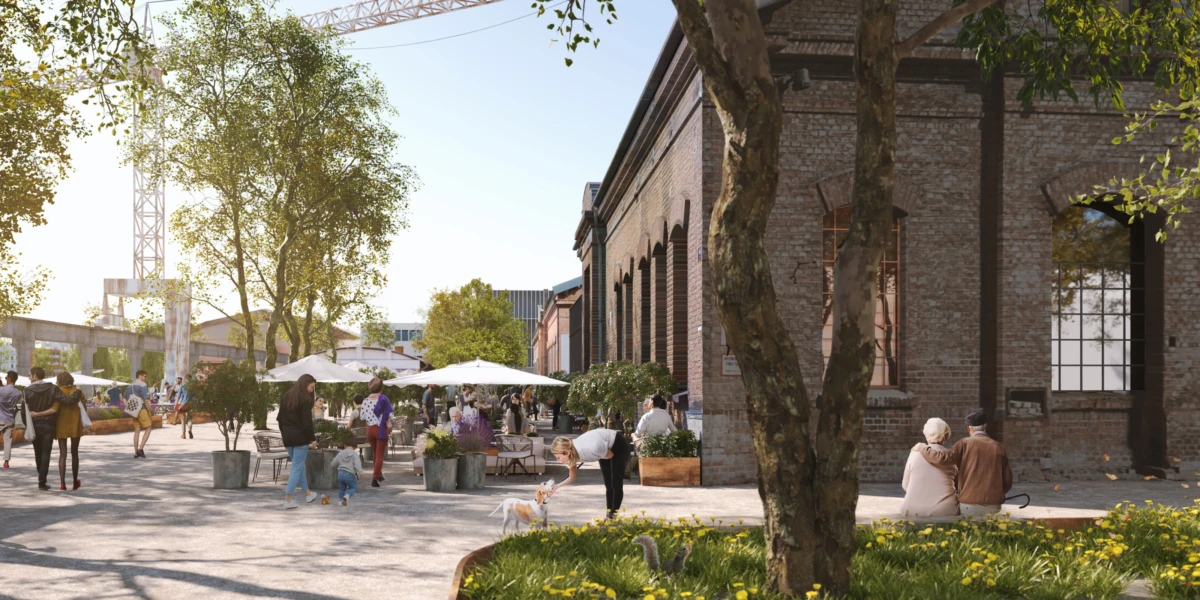 Sunny urban plaza beside a brick building; outdoor cafe under white umbrellas, people walking and chatting, with trees and a distant crane.