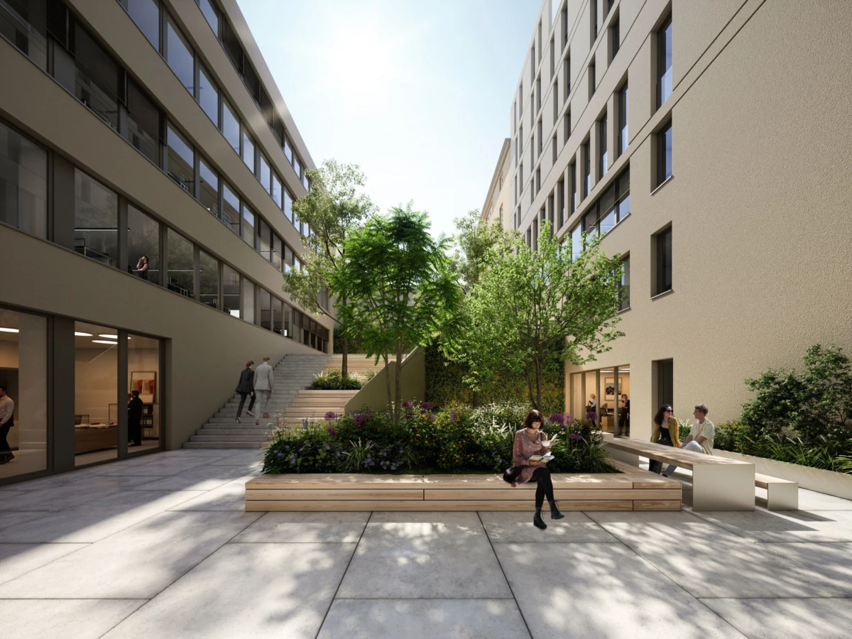 Courtyard between beige modern office buildings with trees and planters; people sit, read, and walk.