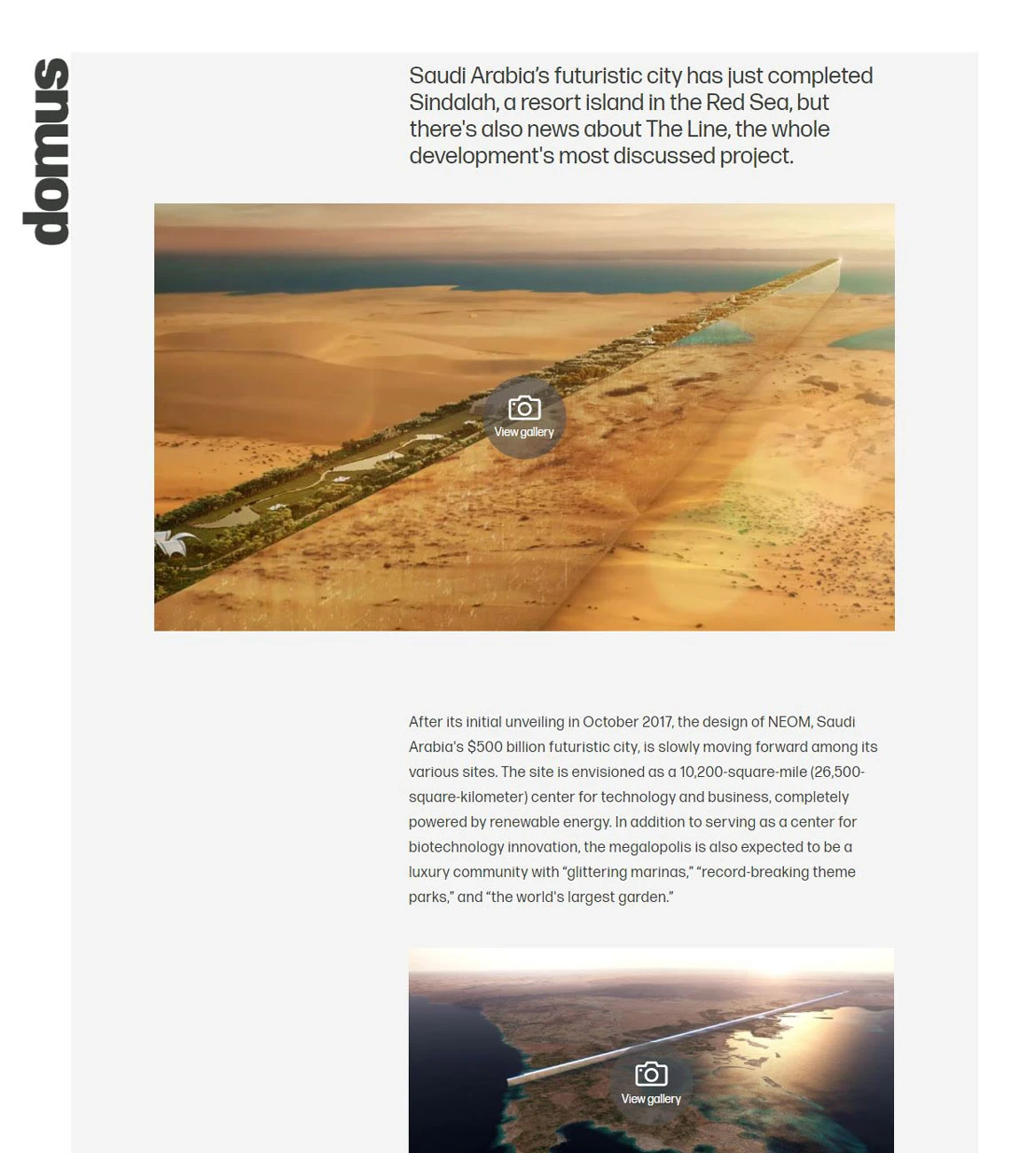 Aerial view of a long, straight elevated road slicing through orange sand dunes toward the sea.