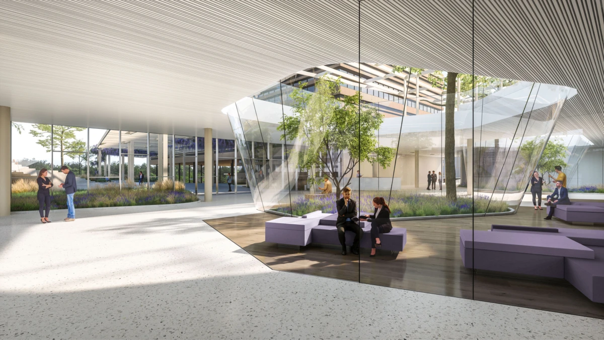 Glass-walled atrium with purple modular seating; two people chat on a purple bench inside, while others mingle in a modern courtyard.