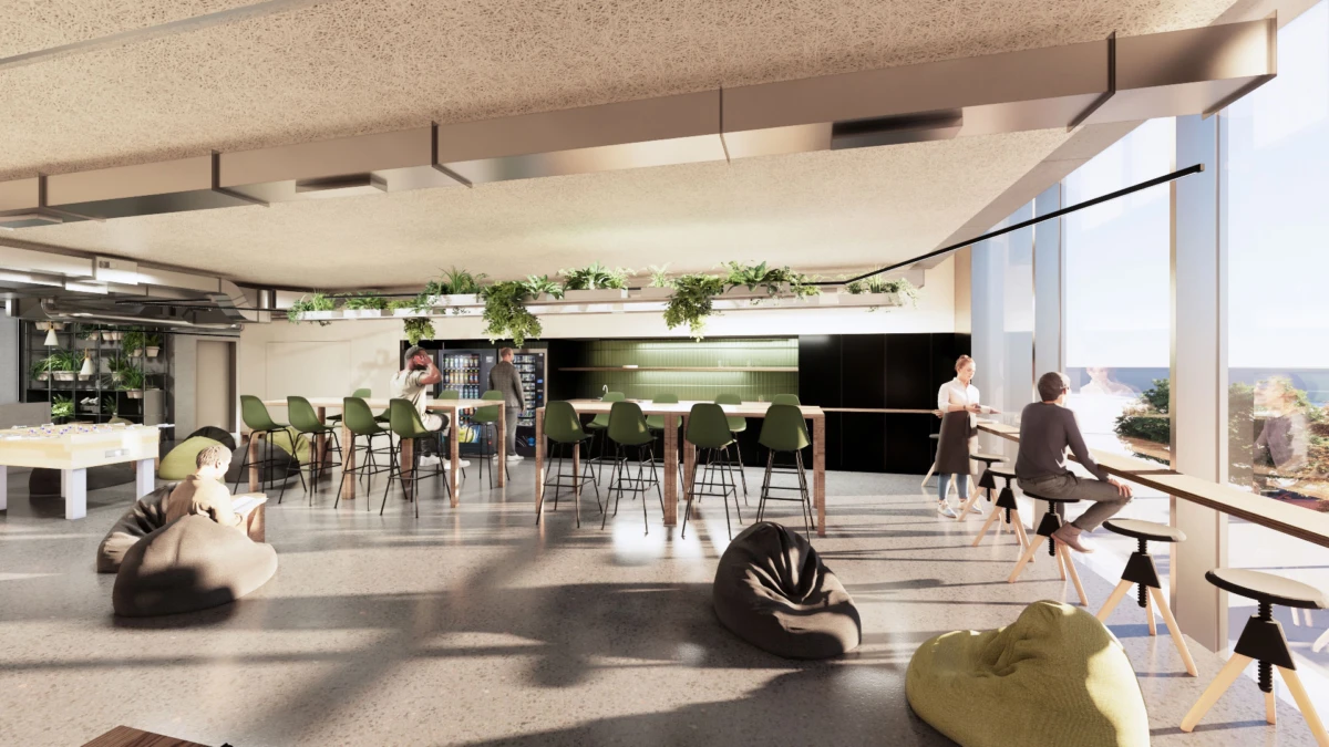 Open-plan coworking lounge with a bar, green stools, bean bags, and people chatting by large windows with an outdoor view.