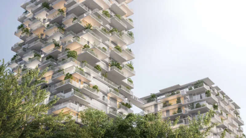 Two modern high-rise residential towers with cascading, plant-filled balconies and a connecting skybridge, set among green trees.