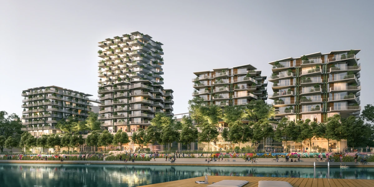 Modern high-rise residential towers along a tree-lined waterfront promenade, with people strolling and a wooden deck by the water.