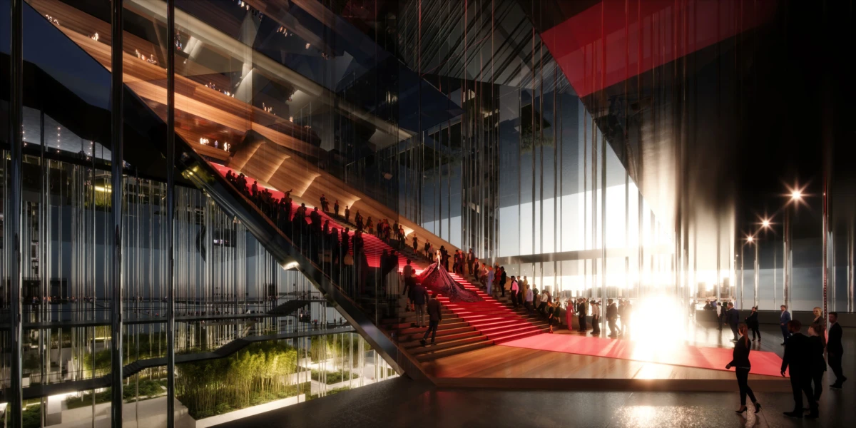 People ascend a red-carpet staircase inside a glass-walled modern venue at night, illuminated by bright right-side lights.