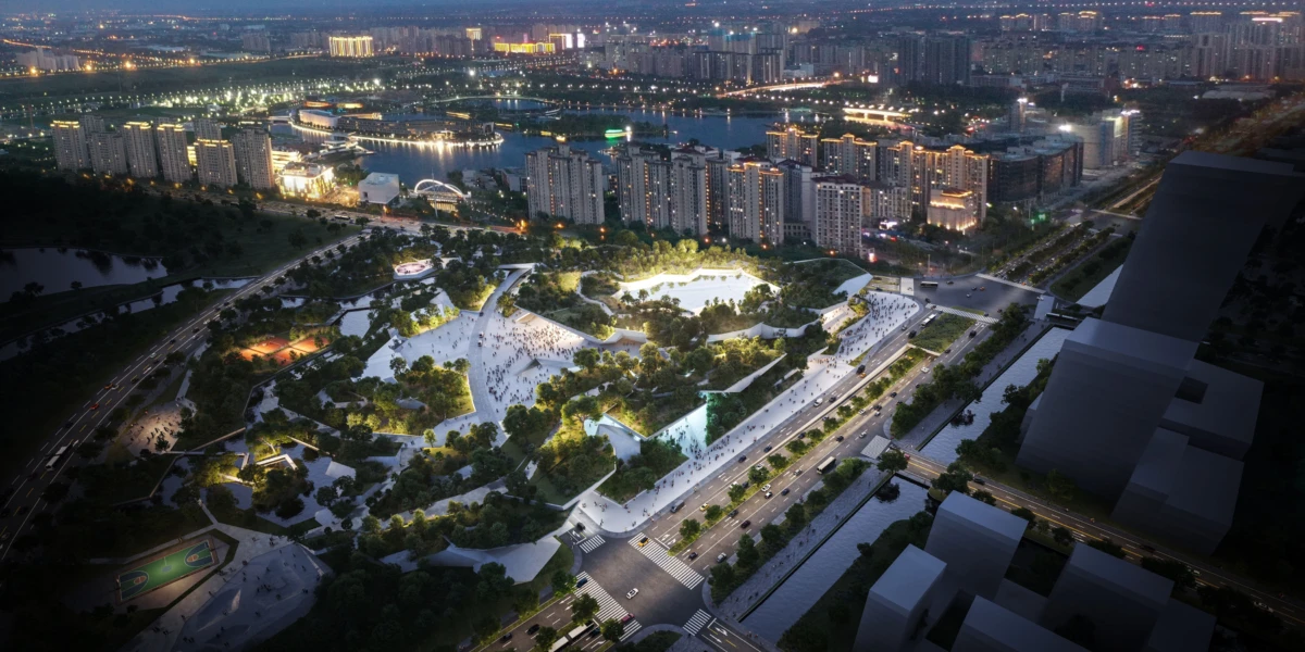 Aerial view of a modern urban park with white angular pavilions and terraced greenery, busy with people, surrounded by high-rise apartments at dusk.