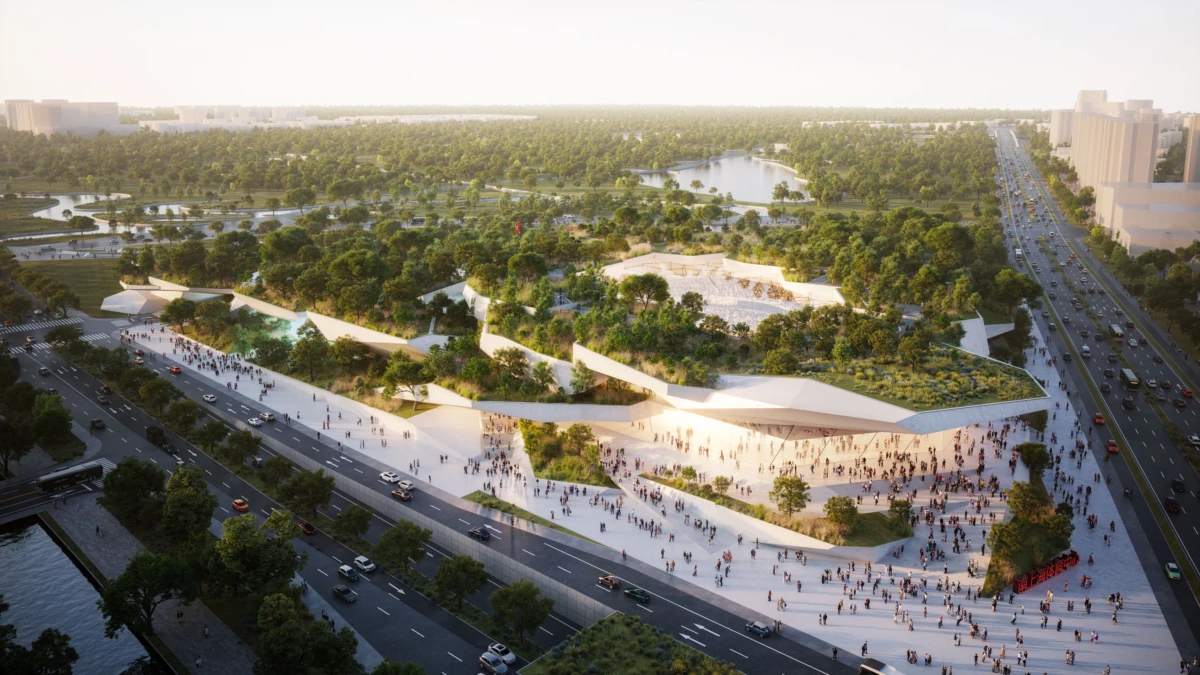 Aerial view of a modern urban park with white angular terraces and crowds, bordered by highways and a distant lake.