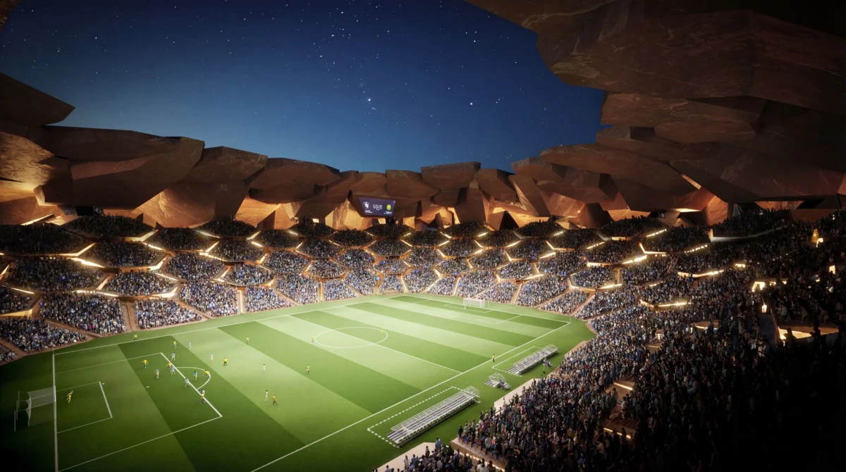Packed football stadium at night with players on the pitch under a starry sky.