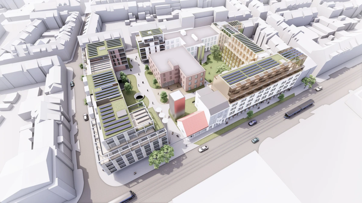 Aerial view of a modern urban development with interconnected mixed-use buildings, green rooftops, solar panels, and a central courtyard.