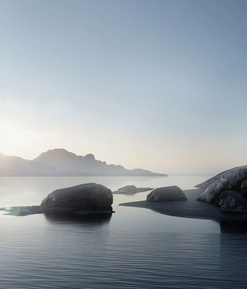 Rocks resting in calm water along a rocky shore with distant mountains on the horizon at sunrise.