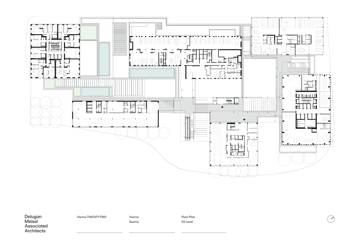 Architectural floor plan of a multi-wing building complex with rooms, corridors, stairs, and surrounding landscape cues.