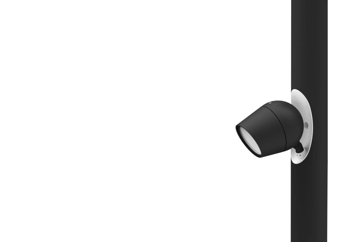 Black outdoor spotlight mounted on a vertical pole, angled outward from a white circular mounting plate.